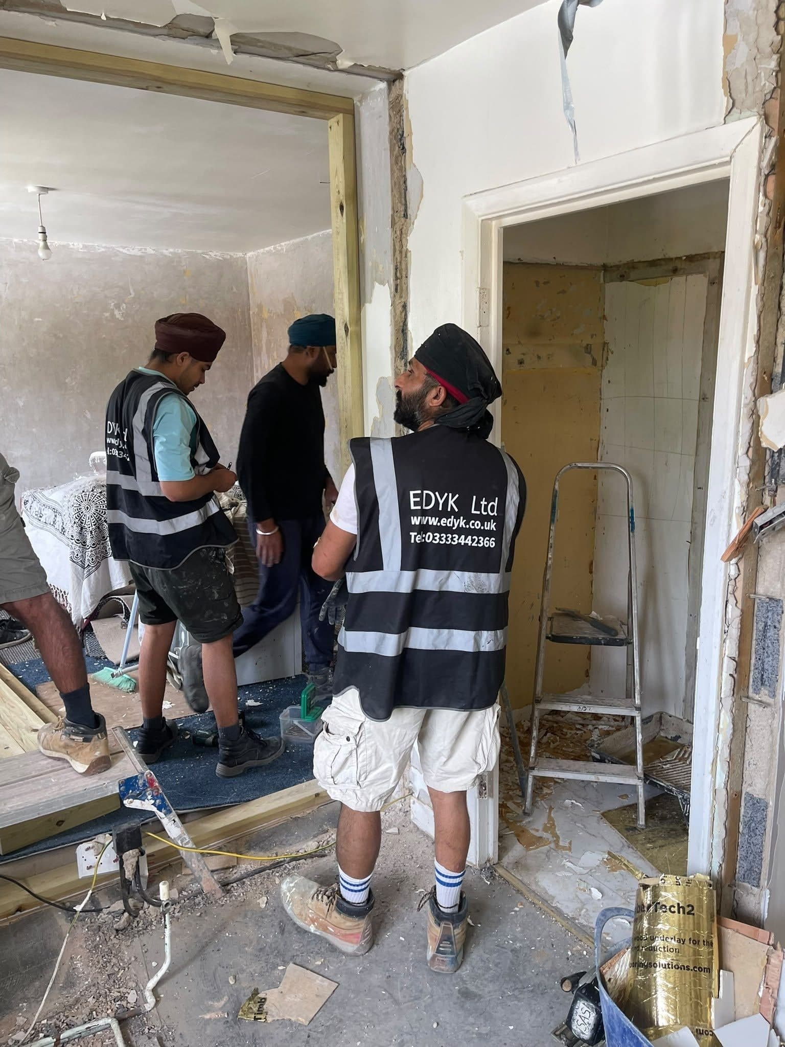 EDYK team members during the strip-out of a flat, with new timber framing around an opening