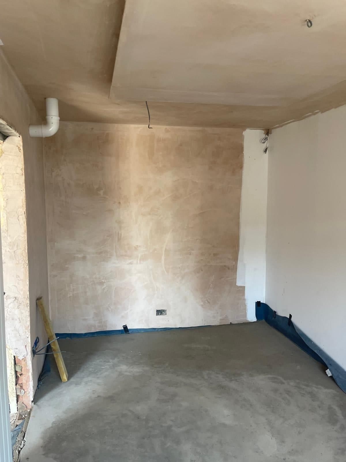 Inside the house extension with plastered ceiling and walls and a concrete floor