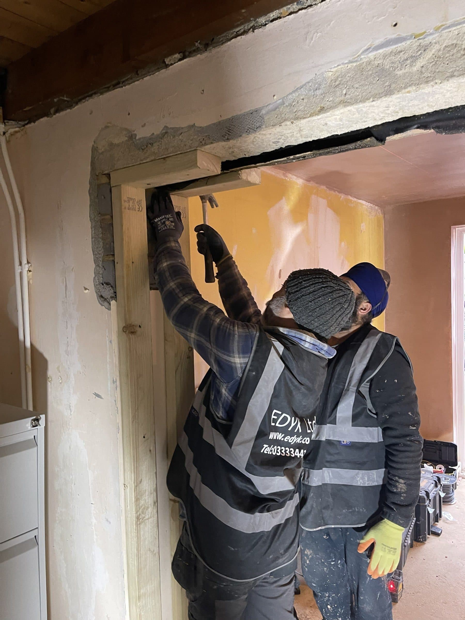 EDYK team fitting a timber frame into a new opening in an internal wall