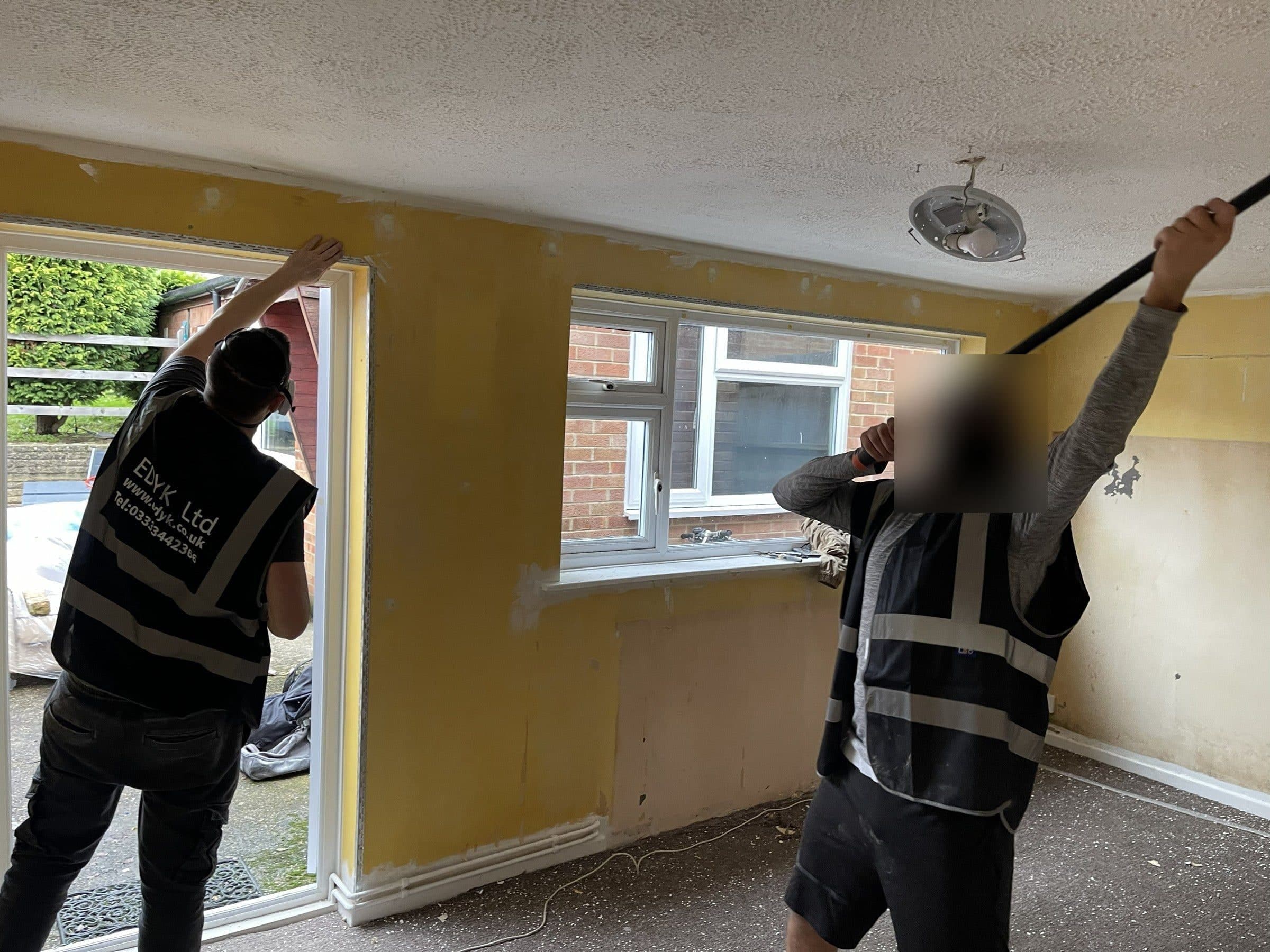 EDYK team members working on the walls and ceiling of a room during the renovation