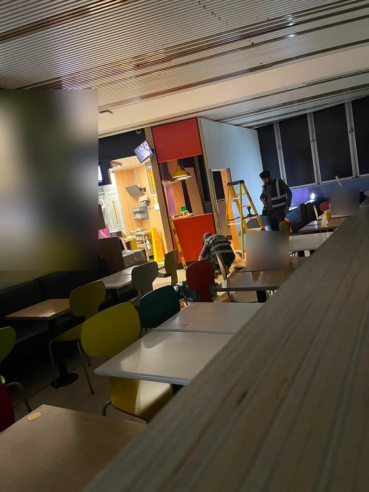 Restaurant dining area during the fit-out, with team members building a new counter in the background