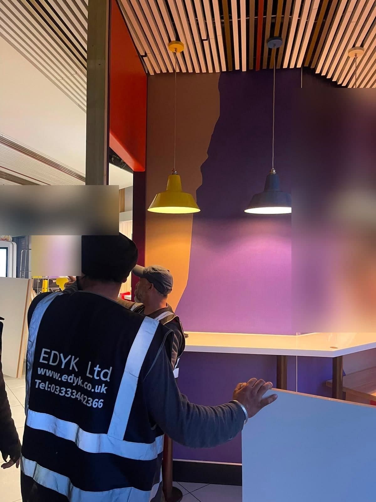 EDYK team members discussing the new counter and partition, with pendant lights above